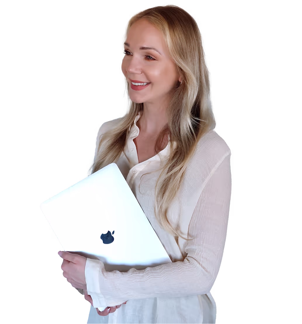 Uśmiechnięta kobieta o długich blond włosach trzymająca zamkniętego srebrnego laptopa MacBooka.